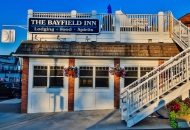 a building with stairs leading to roof with blue sign that ready the Bayfield Inn